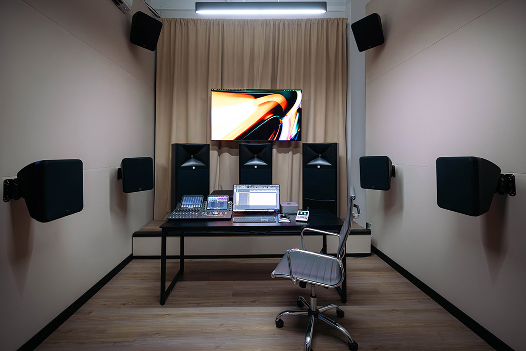 Wide shot of Suite One showing the workstation and speakers in the room.